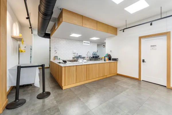 a kitchen with stainless steel appliances kitchen island granite countertop a refrigerator and a sink