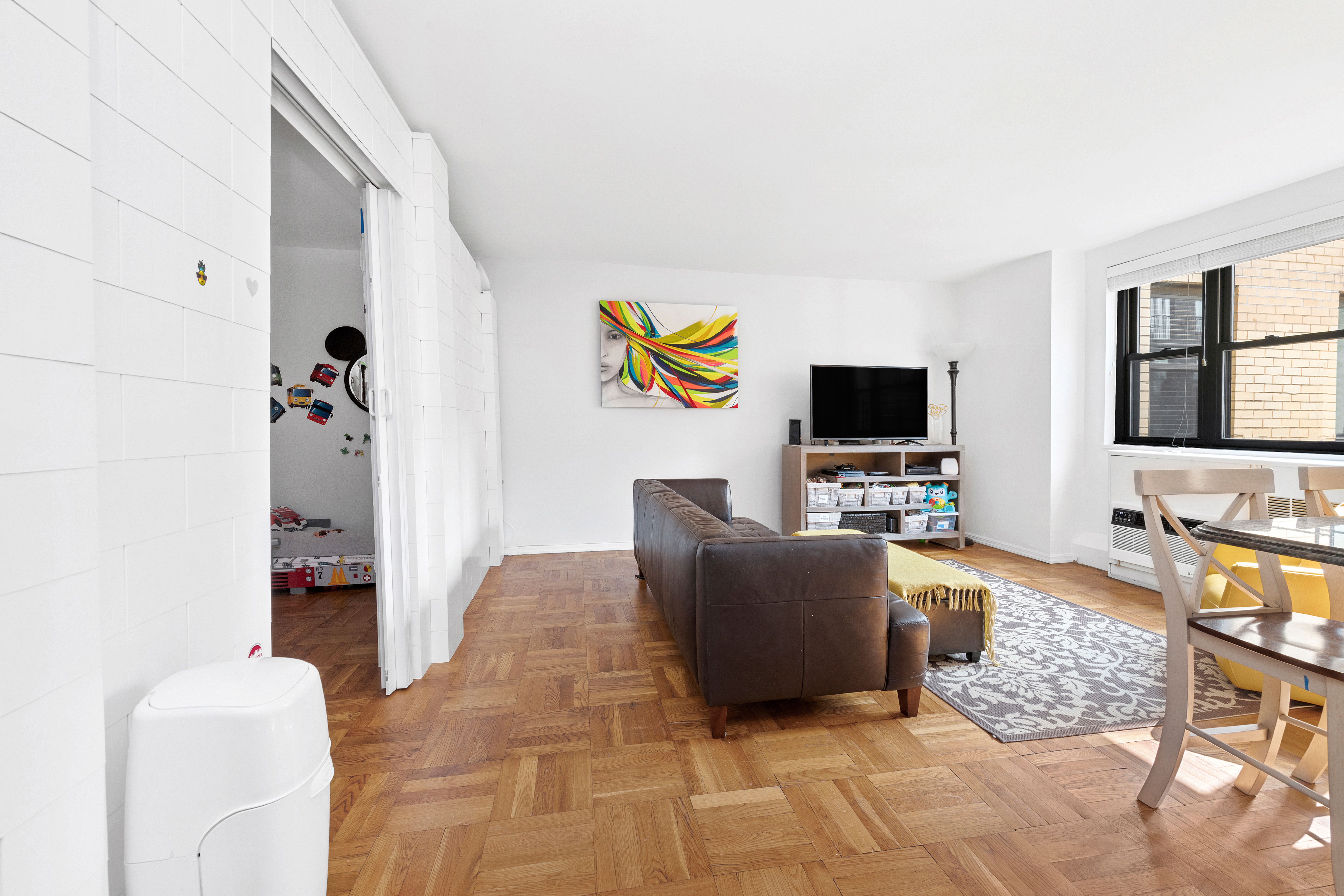 315 East 72nd Street, Unit 15M Manhattan, NY 10021 - Photo 11 of 18 a living room with furniture and a flat screen tv