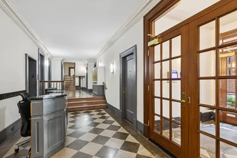 a view of a hallway with wooden floor and a living room