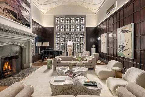 a living room with furniture a fireplace and a floor to ceiling window