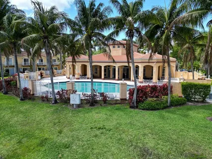 a front view of a house with garden and trees