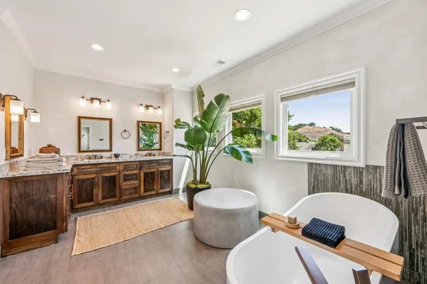 a white bath tub sitting next to a white cabinet