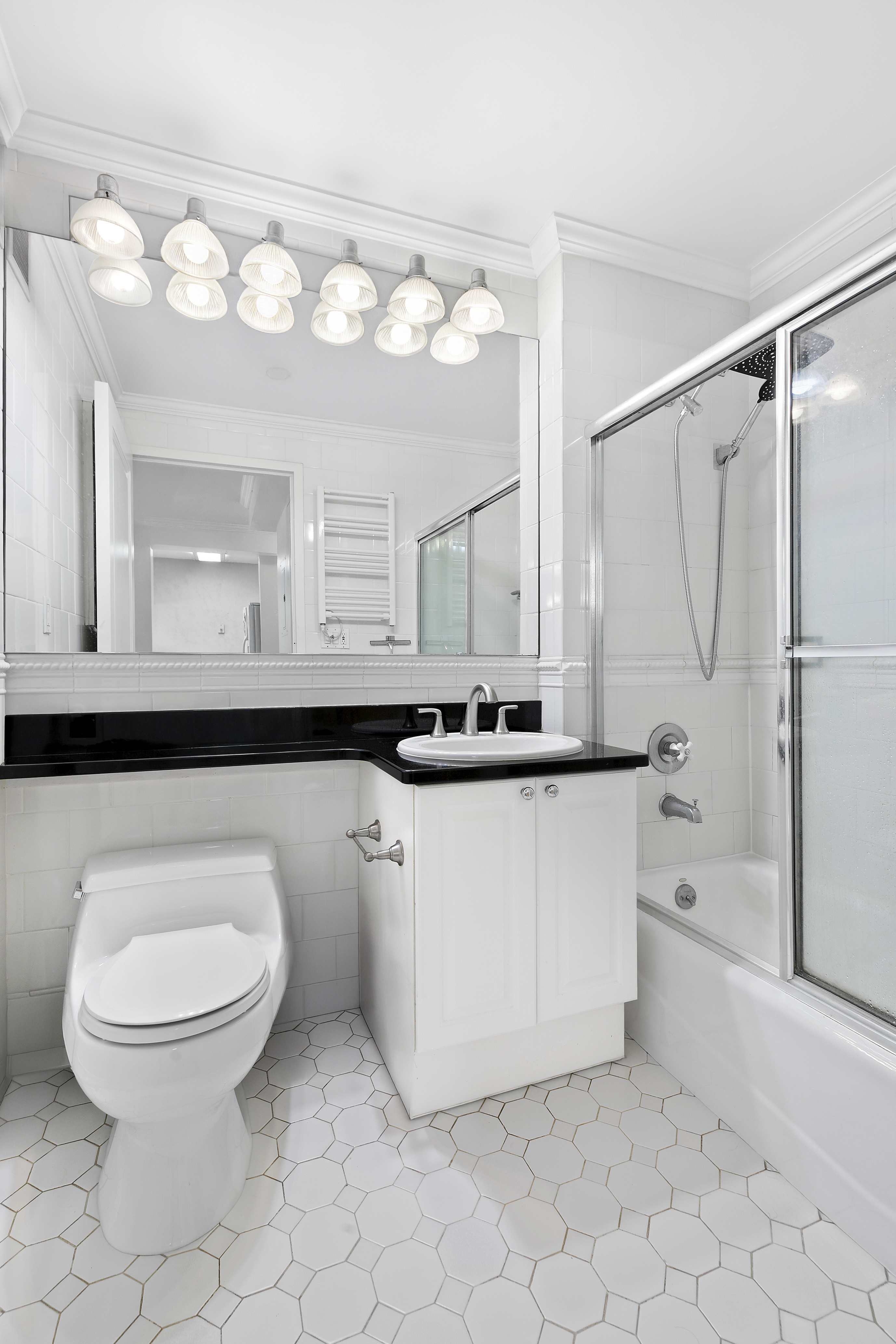 404 East 76th Street, Unit 4H Manhattan, NY 10021 - Photo 8 of 10 a bathroom with a sink a toilet and a mirror