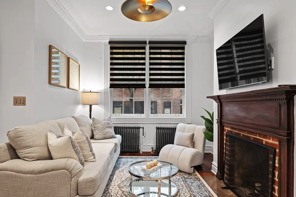 58 Downing Street Manhattan, NY 10014 - Photo 3 of 21 a living room with furniture a fireplace and a large window