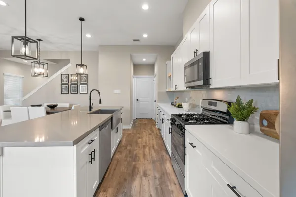 a kitchen with stainless steel appliances granite countertop a sink a stove and a refrigerator