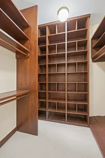 a large white kitchen with stainless steel appliances granite countertop a stove a sink dishwasher and white cabinets with wooden floor