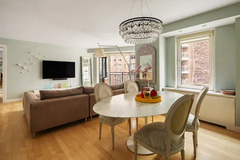 a living room with furniture a flat screen tv and a large window