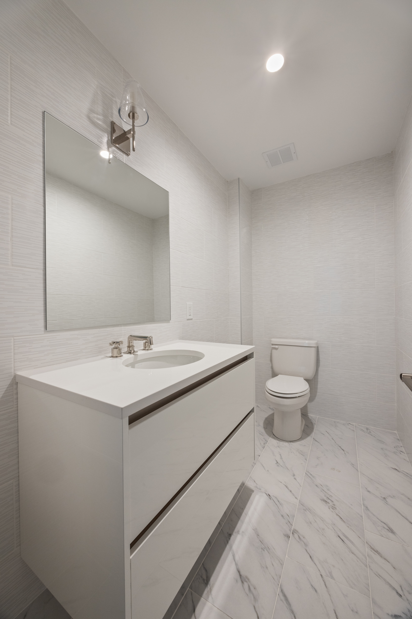 55 Liberty Street, Unit 12C Manhattan, NY 10005 - Photo 9 of 10 a bathroom with a sink toilet and mirror