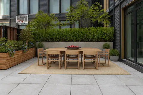 a patio with table and chairs and potted plants