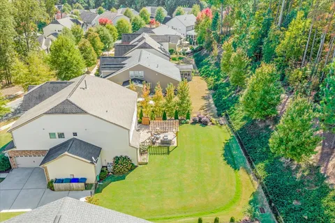 an aerial view of a house with swimming pool and large trees