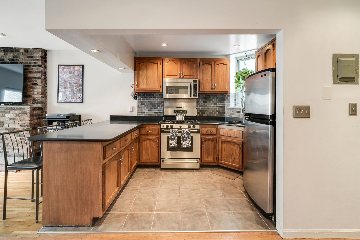 a kitchen with stainless steel appliances granite countertop a stove a sink and a refrigerator