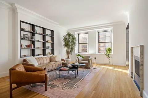 a living room with furniture a fireplace and a wooden floor