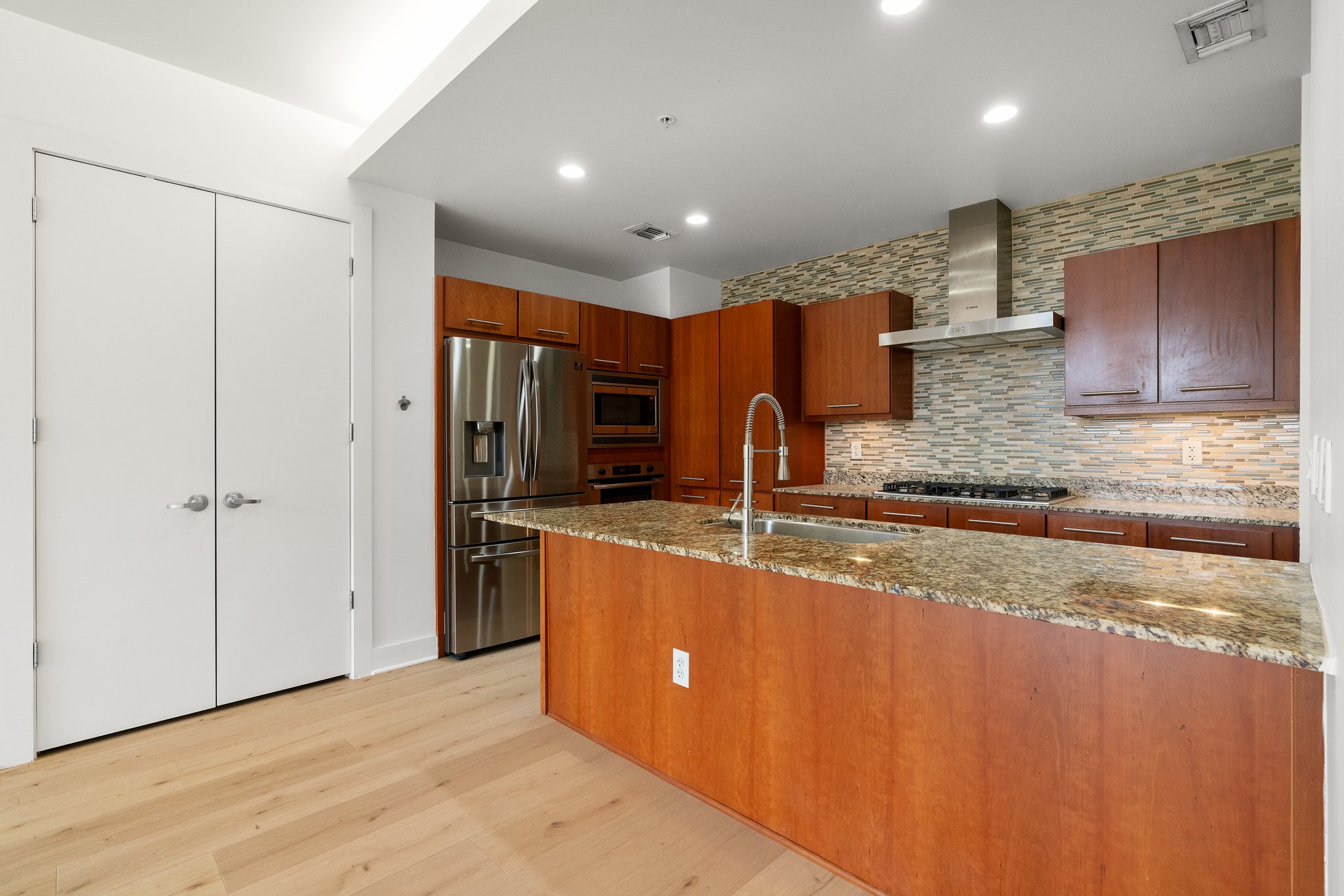 210 Lee Barton Drive, Unit 517 Austin, TX 78704 - Photo 14 of 32 a large kitchen with stainless steel appliances granite countertop a sink refrigerator and cabinets