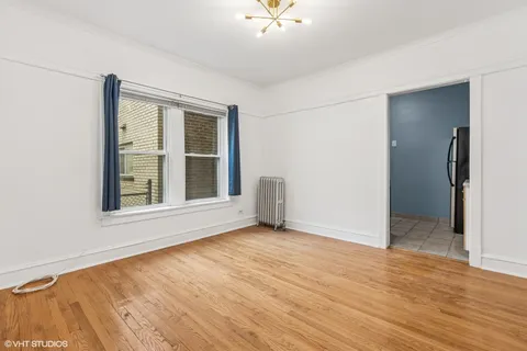 an empty room with wooden floor and a ceiling fan