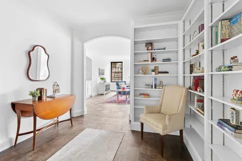 a living room with furniture and a book shelf