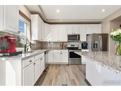 a kitchen with granite countertop a refrigerator stove and sink
