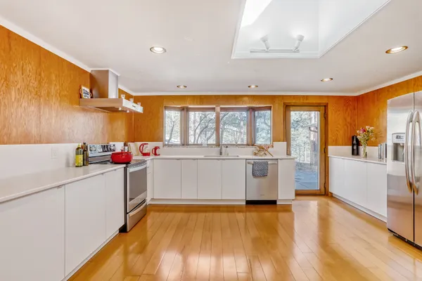 a bedroom with a bed wooden floor and window