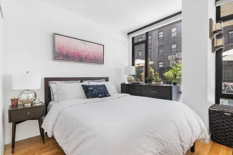 a bed sitting in a bedroom next to a window
