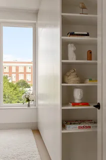 a hallway with a book shelf with a window