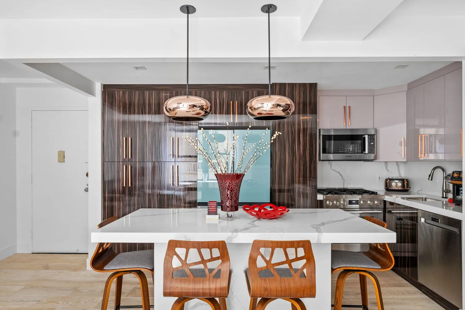 a kitchen with a refrigerator a stove a sink and a dining table with wooden floor