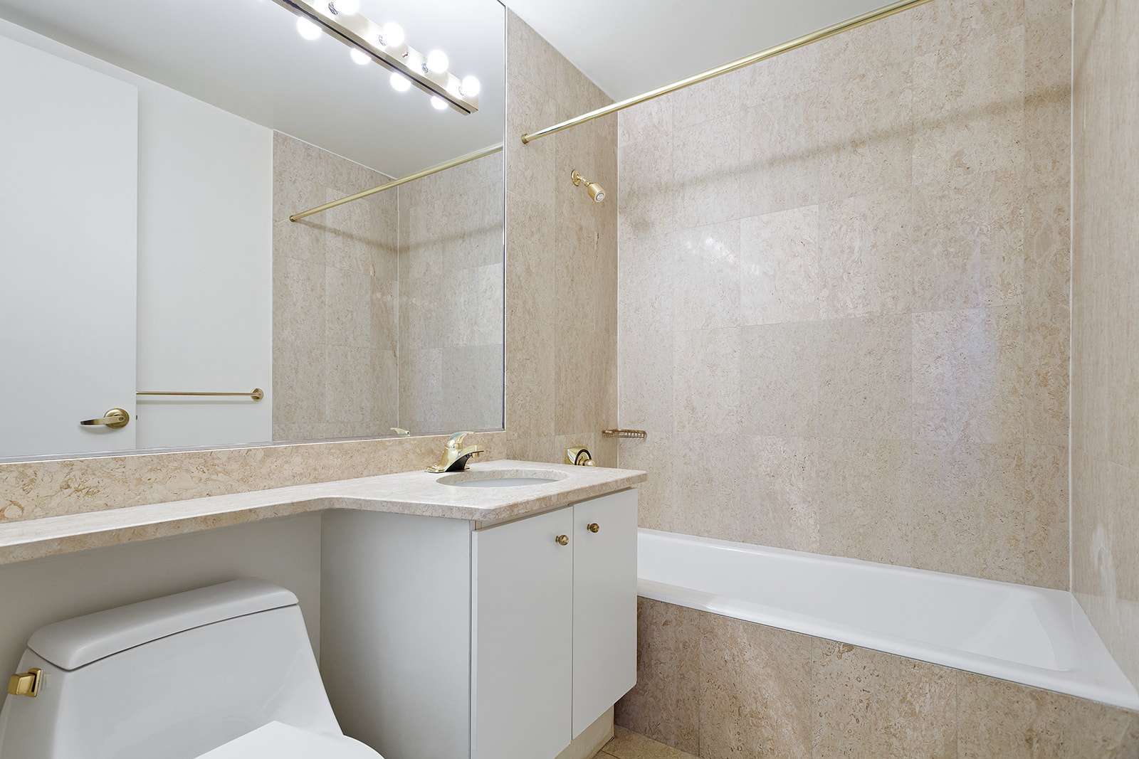 1965 Broadway, Unit 11D Manhattan, NY 10023 - Photo 11 of 13 a bathroom with a sink a toilet and a mirror