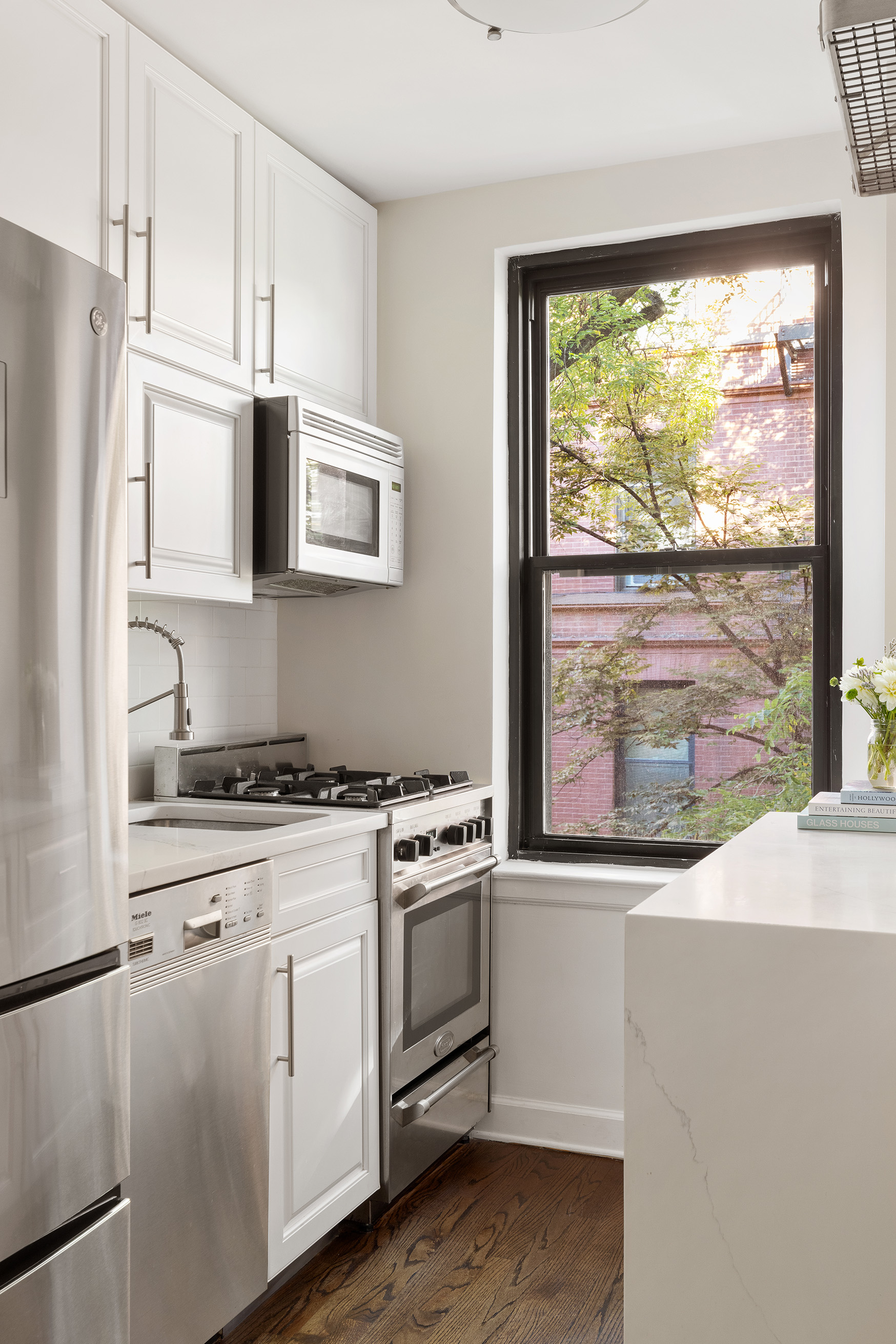 81 Bedford Street, Unit 4B Manhattan, NY 10014 - Photo 9 of 15 a kitchen with a stove a sink and a refrigerator