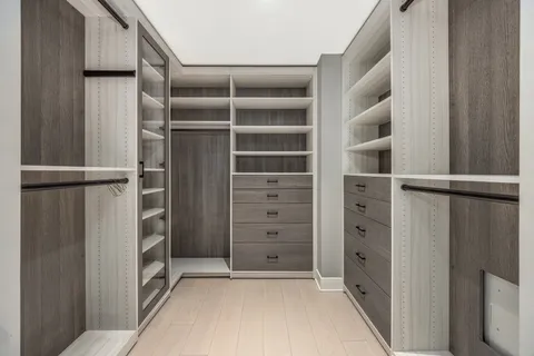 a view of walk in closet with empty racks