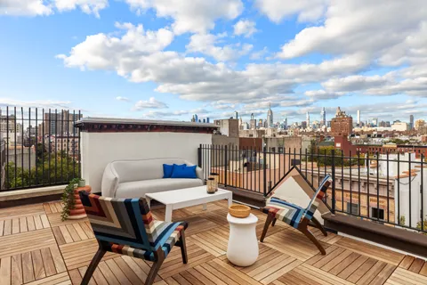 a view of a balcony with two chairs and a potted plant