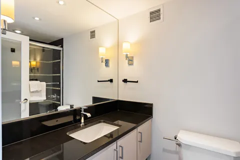 a bathroom with a sink a toilet and shower