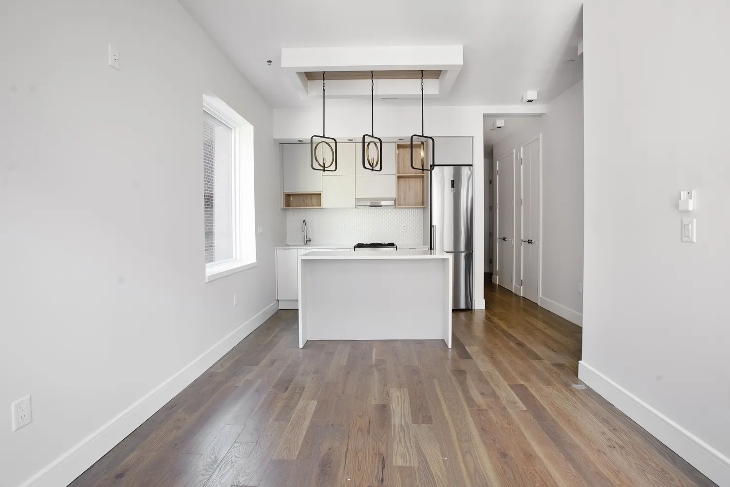 a kitchen with stainless steel appliances a refrigerator and a wooden floor