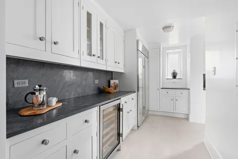 a kitchen with white cabinets and sink