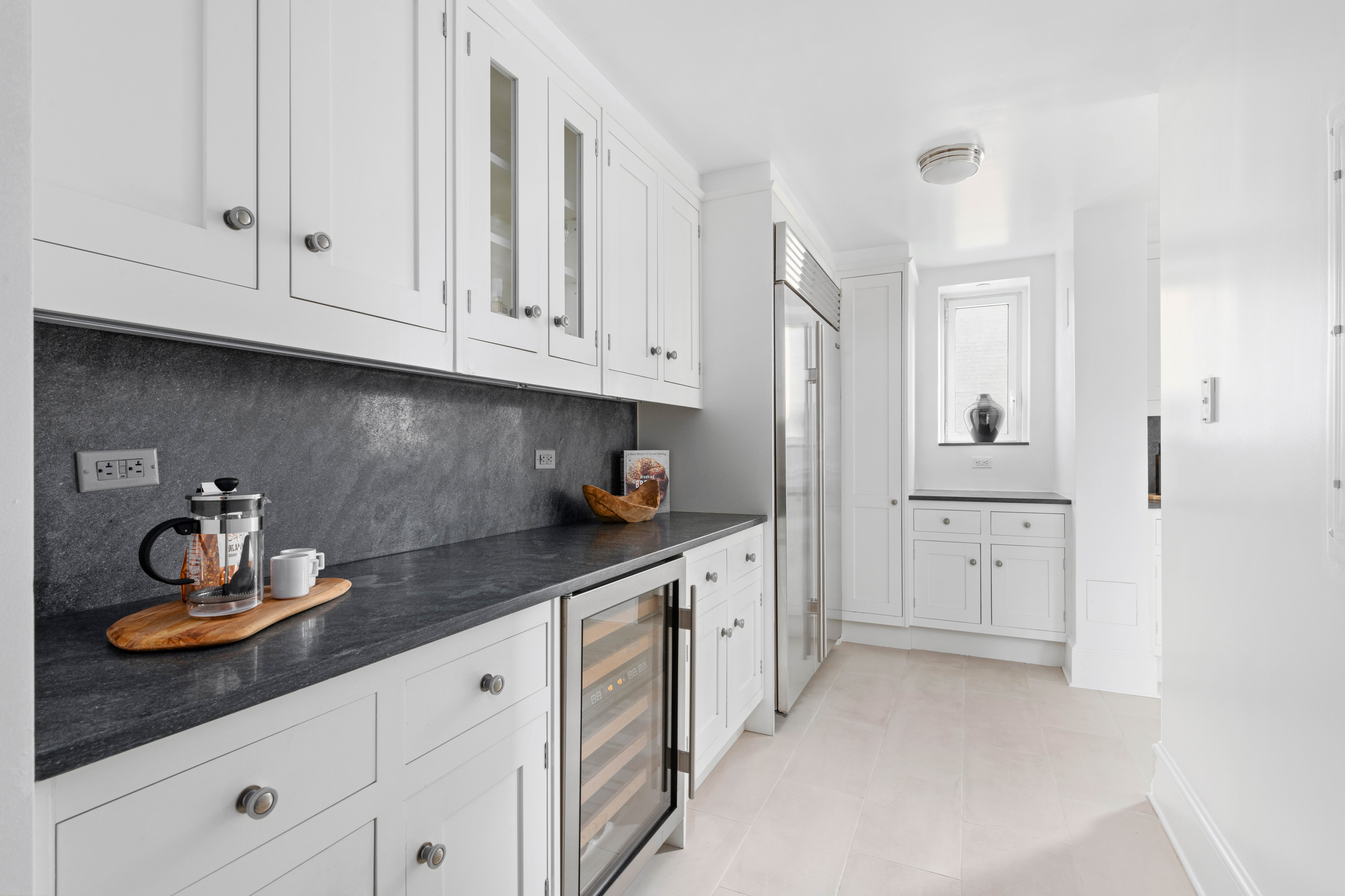 530 Park Avenue, Unit 12F Manhattan, NY 10065 - Photo 8 of 26 a kitchen with white cabinets and sink