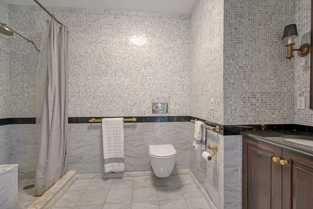 a bathroom with a granite countertop shower and a toilet