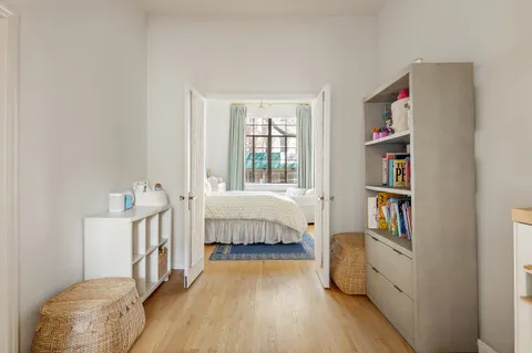 a spacious bedroom with a bed and a book shelf