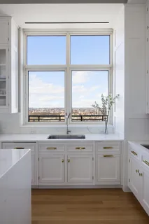 a view of a kitchen with a sink and wooden cabinets