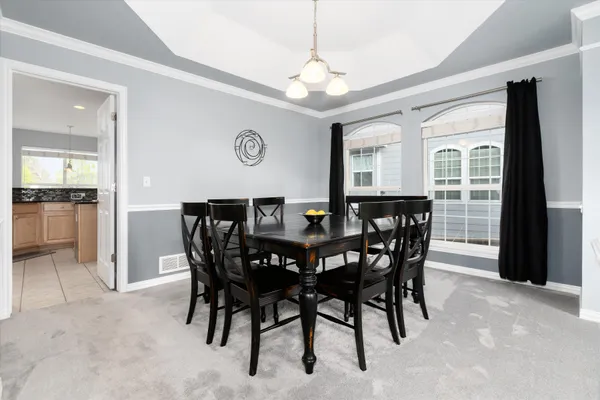 a view of a dining room with furniture and a chandelier
