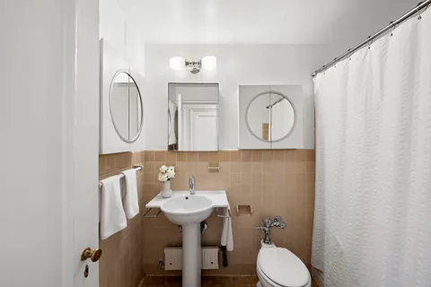 a bathroom with a toilet sink and mirror