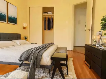 a bedroom with a bed and wooden floor