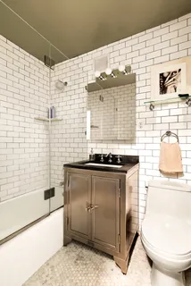 a bathroom with a granite countertop sink a toilet and bathtub