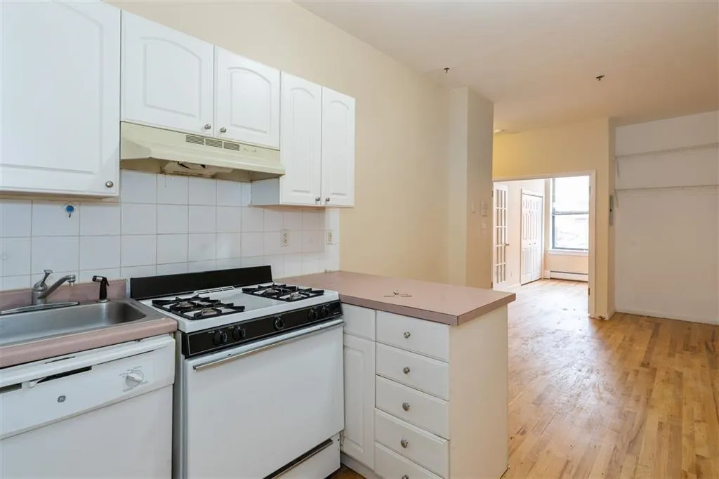 a kitchen with granite countertop a stove a sink and cabinets