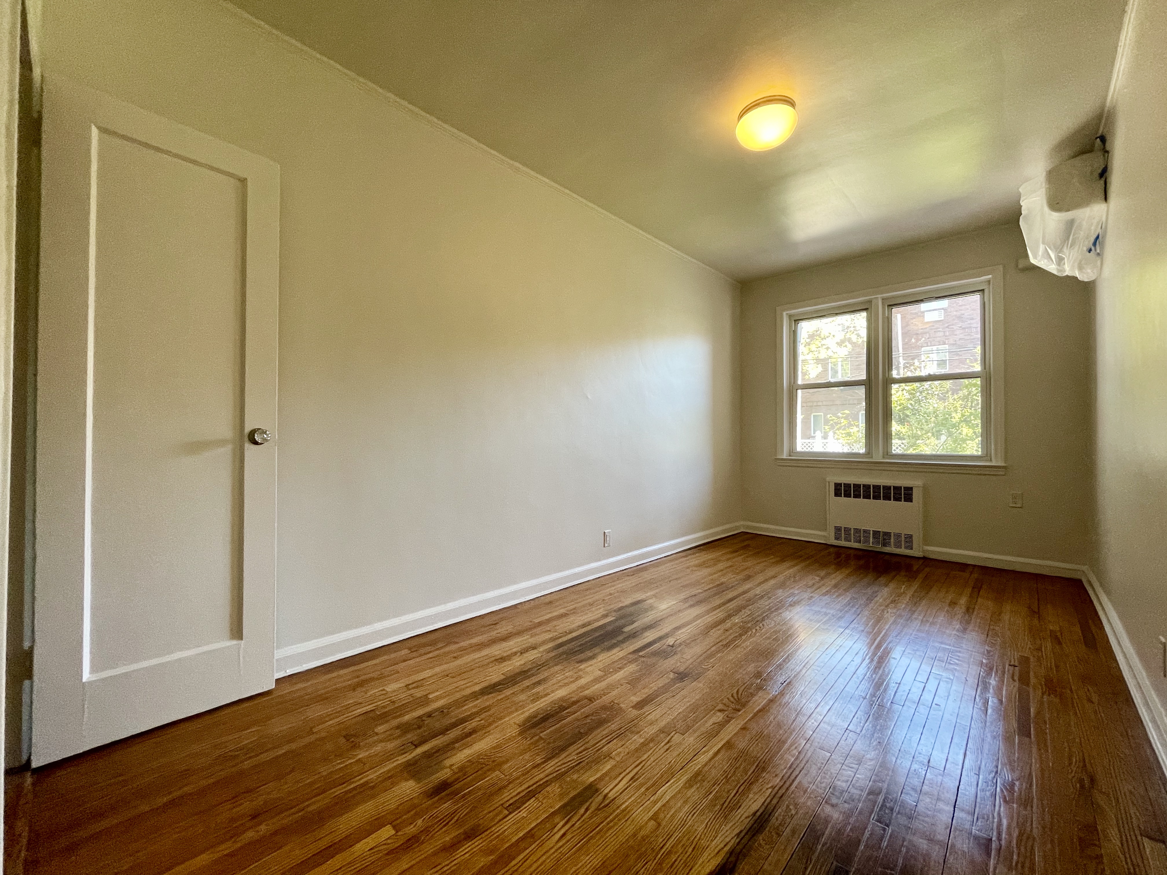144 96th Street Brooklyn, NY 11209 - Photo 7 of 9 an empty room with wooden floor and windows