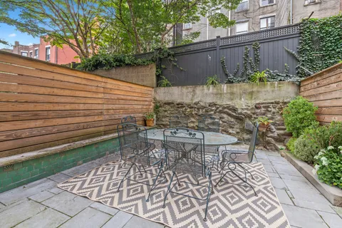 a view of a chairs and table in backyard
