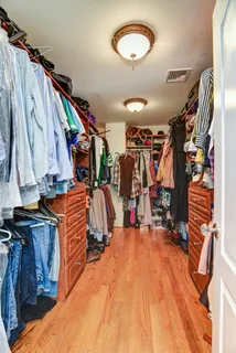 a view of walk in closet with clothes and shoes