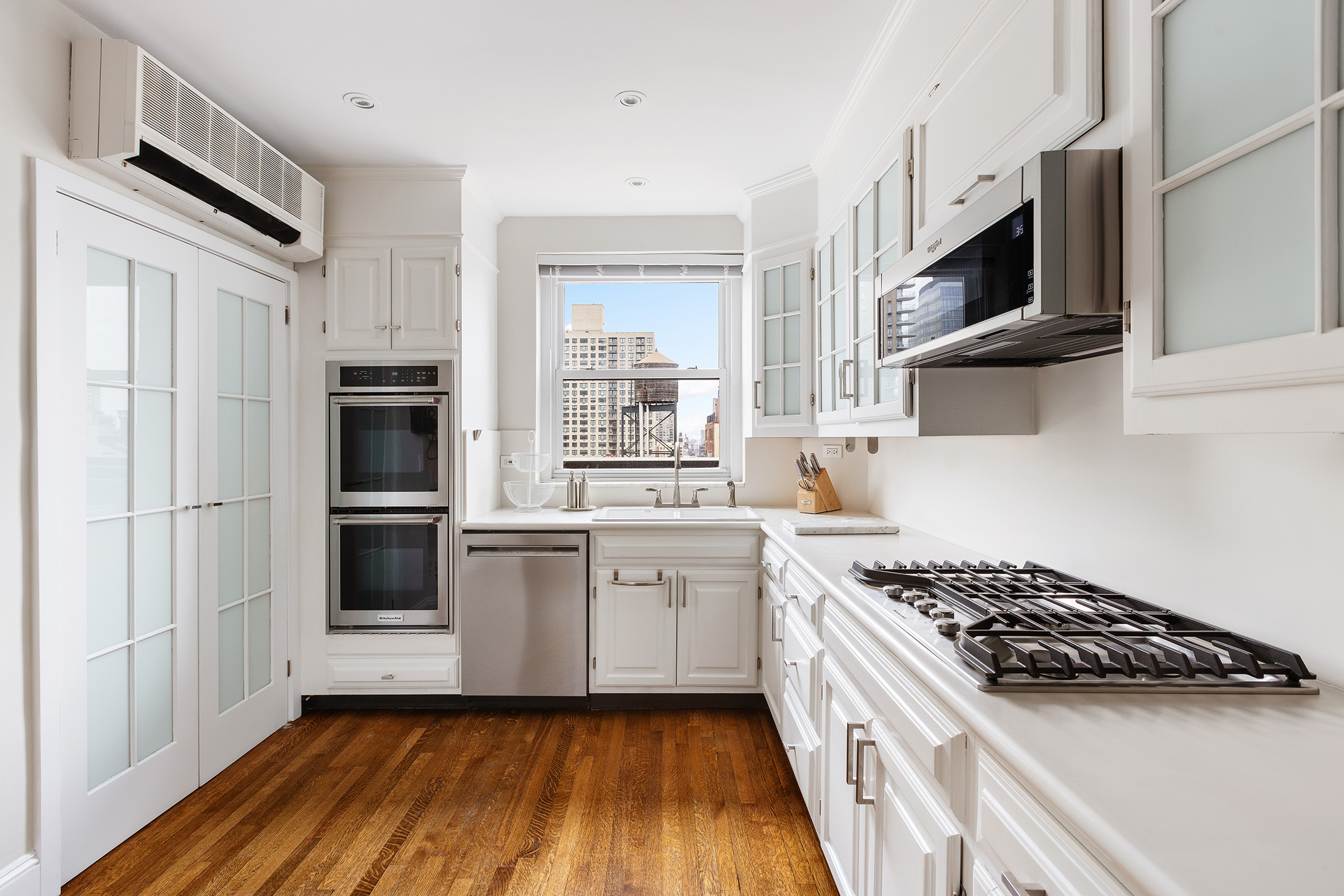 320 East 72nd Street, Unit PHB Manhattan, NY 10021 - Photo 8 of 26 a kitchen with stainless steel appliances a white stove top oven and sink