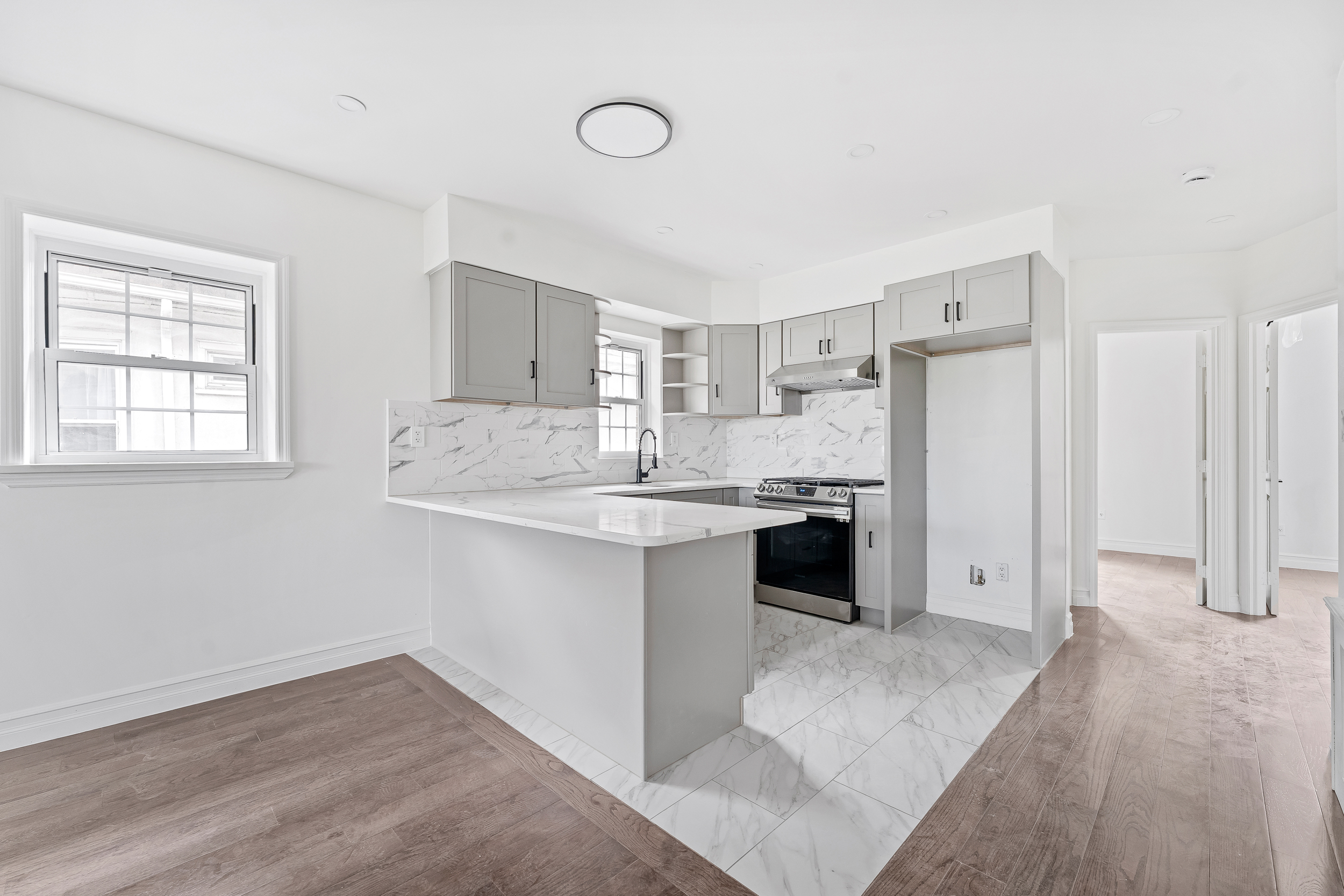 65 Bay 23rd Street, Unit 2 Brooklyn, NY 11214 - Photo 6 of 16 a kitchen with a refrigerator and white cabinets