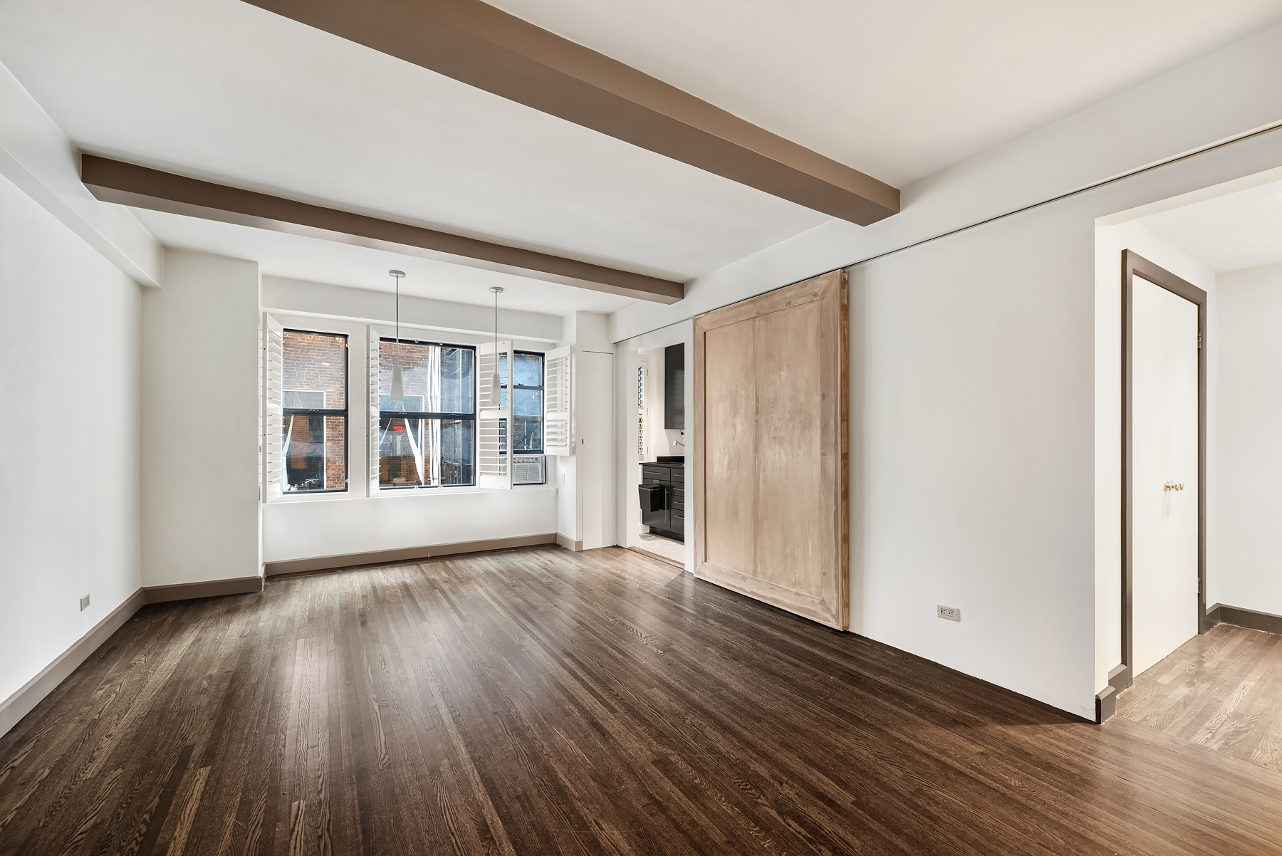 339 East 58th Street, Unit 3J Manhattan, NY 10022 - Photo 1 of 9 a view of an empty room with wooden floor and a window