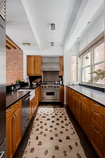 a large kitchen with stainless steel appliances a stove a sink and a microwave