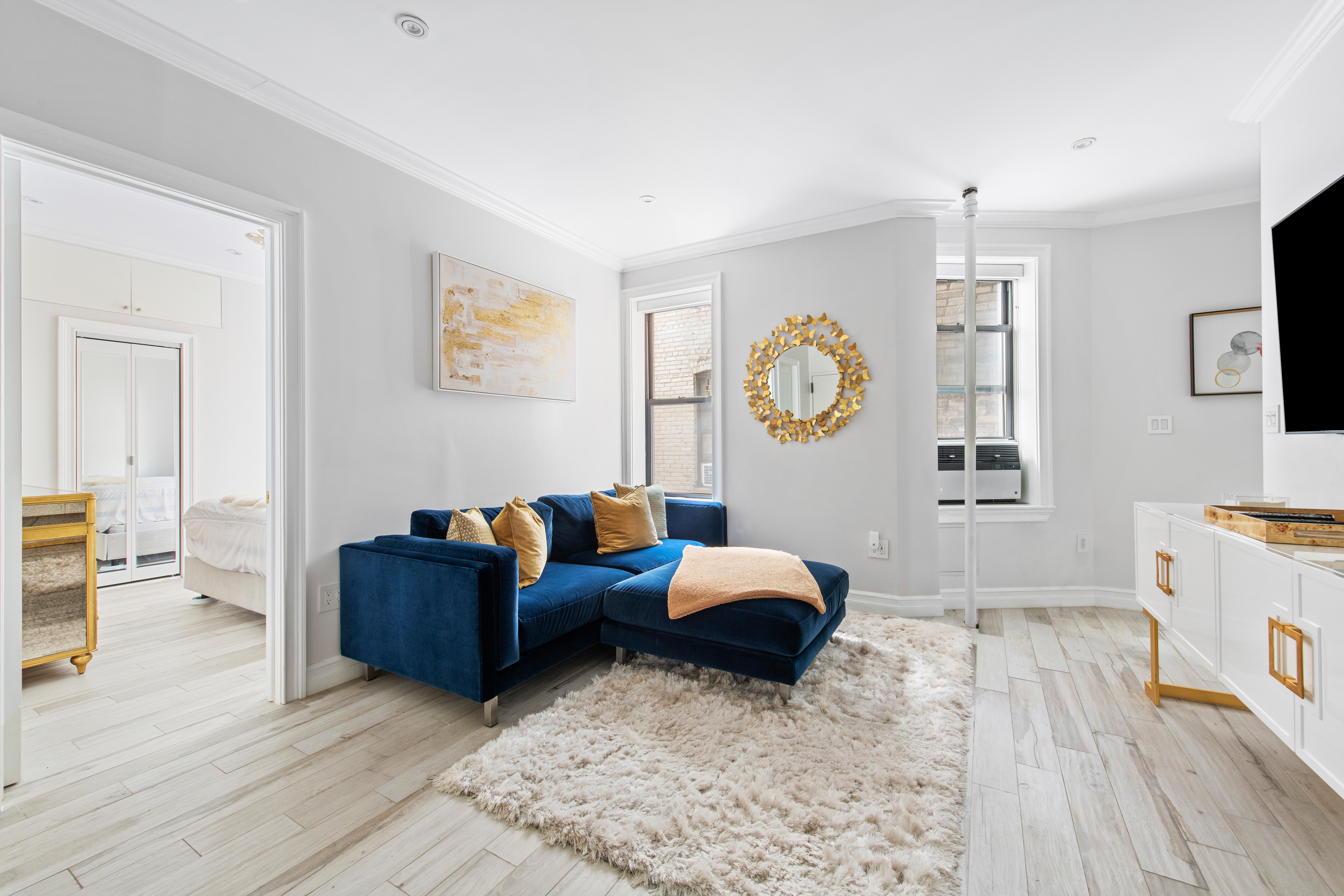 135 Ridge Street, Unit 5A Manhattan, NY 10002 - Photo 4 of 11 a living room with furniture and a flat screen tv