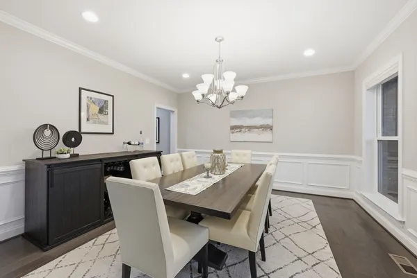 a dining room with wooden floor and a chandelier