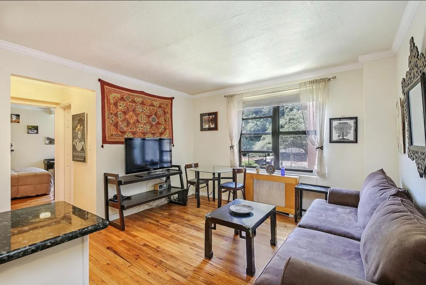a living room with furniture and a flat screen tv with wooden floor